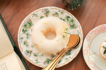 Donut with lemon glaze on luxury plate with green floral style and golden spoon. Freshly homemade baked.