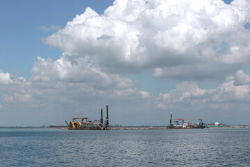 Heavy dredging machinery ships digging in the middle of an ocean