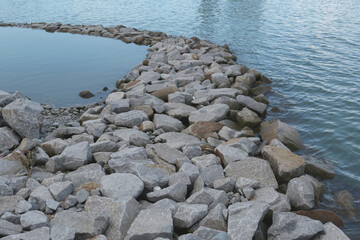 View of an ocean breakwater made by stacking big boulders on top of each other