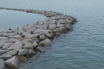 View of an ocean breakwater made by stacking big boulders on top of each other