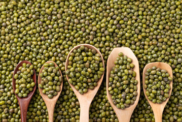 Mung bean in difference wooden spoon with mung bean seed background, Asian food ingredient