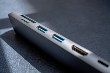 Photograph of a metallic gray USB hub focusing on the memory card slots