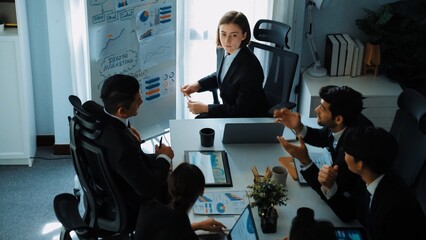 Top view of smart manager project pointing at whiteboard with mind map and financial graph and explain marketing idea while diverse investors listening and analyze stock investment chart. Directorate.