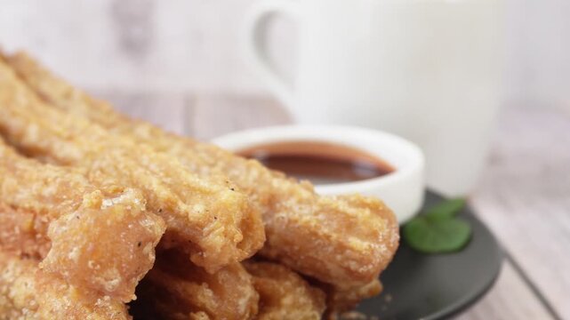 Pan of churros and chocolate on a plate. Mexican food