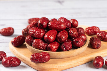 dried red dates on wooden table.