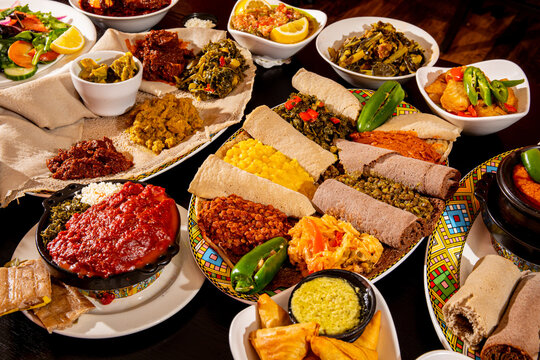 A variety of Ethiopian meat and vegetable dishes with rolls of injera flat bread on a party buffet