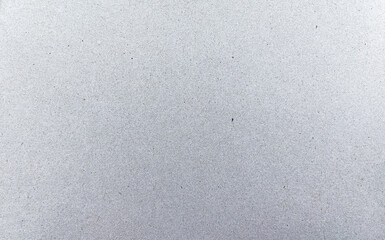 Close-up texture of recycled grey paperboard from milk carton. Natural eco surface ideal for packaging design, background texture, and sustainable creative projects.