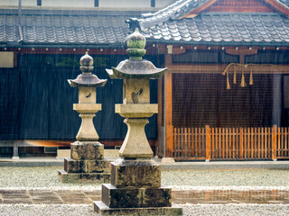 雨に濡れた神社の石灯籠