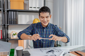 A young architect is multitasking at his desk, sketching blueprints, making phone calls, and reviewing notes. His workspace shows focus, productivity, and modern design work.