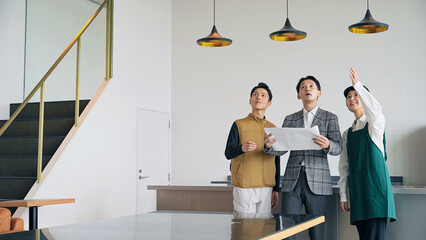 店舗施設で打ち合わせする店員・設計士・作業員