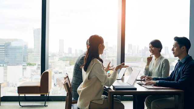 オフィスで会議するカジュアルなビジネスパーソンのグループ
