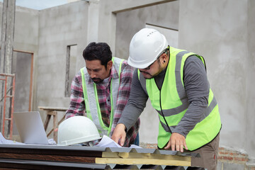 Young overweight engineering foreman discussing teamwork on construction site outdoors with Asian or Indian contractor man business partnership project manager using laptop technology solving problem