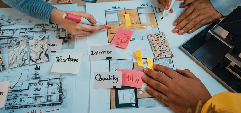 Professionals collaborate on architectural plans and design ideas, using color swatches and notes in a dynamic brainstorming session to create innovative spaces. SACTR