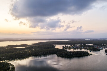 A breathtaking aerial view of Forster on the Mid North Coast of New South Wales, showcasing turquoise ocean waters, white sandy beaches, and the bridge linking Forster and Tuncurry. The scenic coastli