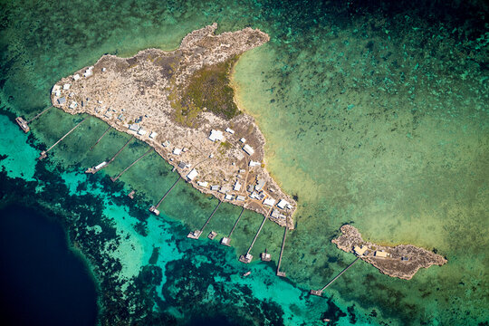 Aerial view of Little Rat Island and Bushy Joe Island surrounded by clear turquoise water.