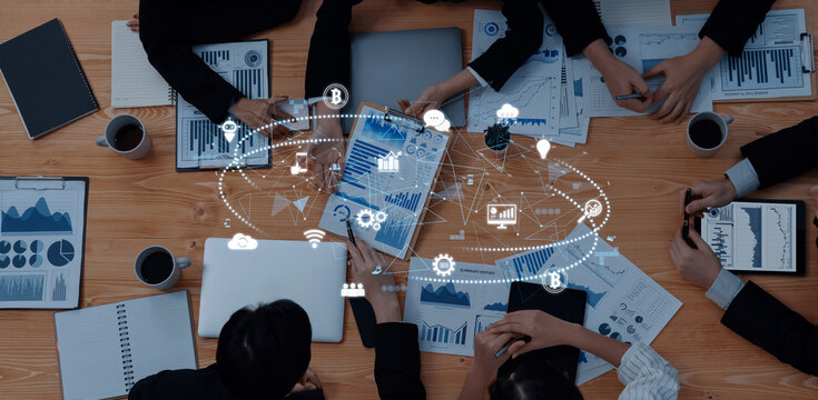 A top-down view of a business meeting emphasizing data analysis, featuring charts, graphs, and digital elements, showcasing teamwork and modern technology. Trope