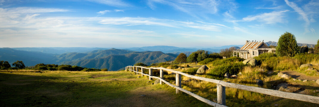 Historic mountain hut overlooking endless blue ranges.