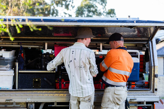 Father and son handyman business team working together by ute