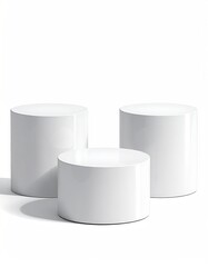 Three white, staggered, cylindrical platforms on a white backdrop
