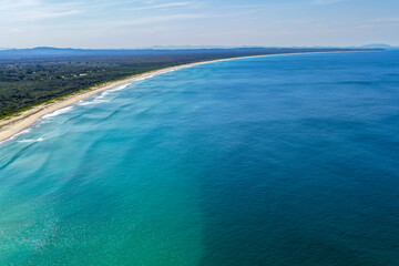 A breathtaking aerial view of Forster on the Mid North Coast of New South Wales, showcasing turquoise ocean waters, white sandy beaches, and the bridge linking Forster and Tuncurry. The scenic coastli