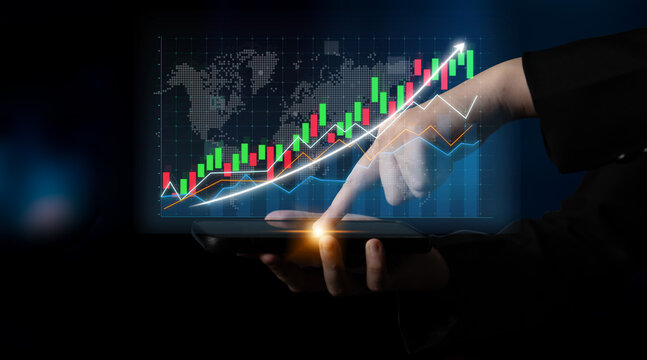 This image captures a close-up of a person analyzing stock market trends on a digital tablet, featuring vibrant graphs and data visualizations in a dark setting. Impute - Powered by Adobe