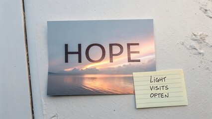 Inspiring message of hope with scenic sunset reflection and motivational note on table near wall