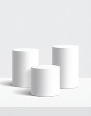 Three white cylinder pedestals on a white surface, neutral space