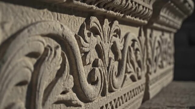 Ornate stone carving with intricate floral and scrollwork patterns on an ancient architectural frieze. - Powered by Adobe