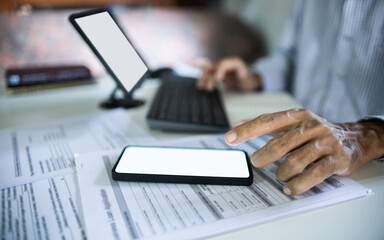 close up shot, asian businessman work at home using mobile phone, laptop connecting to customer, checking documents before making business contract