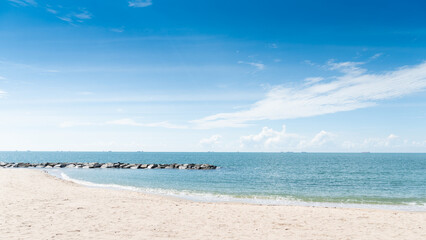 Obraz premium Clean beach area and clear blue sky and turquoise sea with coastal rock barrier. Time to travel with a bright atmosphere at Rayong Thailand.