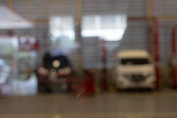 Blurry View of a Car Repair Shop with Equipment and Vehicles