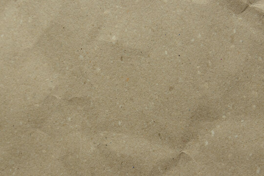Close-up of a crumpled, light brown kraft paper texture. Its earthy tone - Powered by Adobe