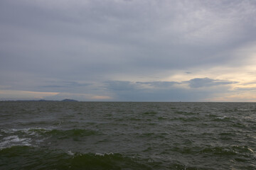 A dramatic sky with layers of dark clouds and a burst of bright sunlight, creating