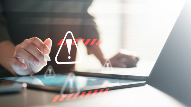 cybersecurity, warning, threat, phishing, malware, breach, Close-up of a person using a digital device with a warning icon overlay, symbolizing cybersecurity threats and data protection.