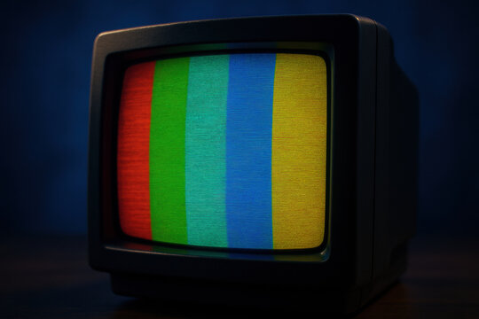 Vintage crt television displaying color test pattern with retro screen texture and dark background, nostalgic electronic device