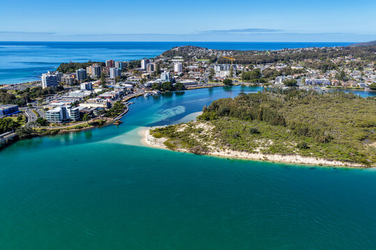 A breathtaking aerial view of Forster on the Mid North Coast of New South Wales, showcasing turquoise ocean waters, white sandy beaches, and the bridge linking Forster and Tuncurry. The scenic coastli