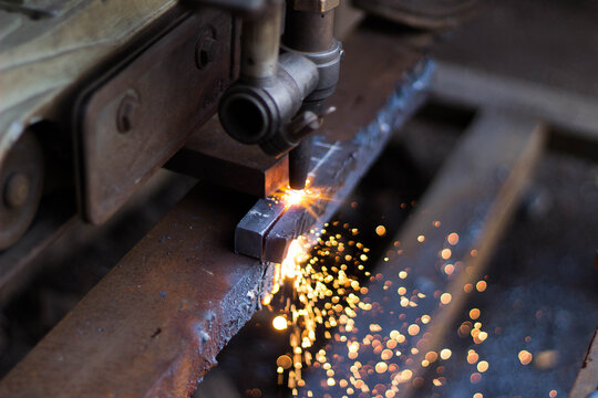 Metal cutting torch with bright sparks in workshop - Powered by Adobe