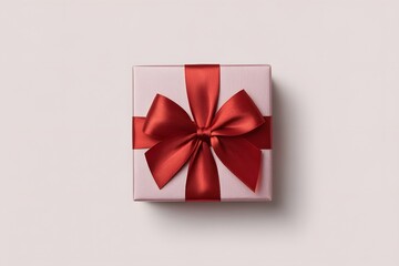 Pink gift box with elegant red satin ribbon bow on a soft light background, overhead view