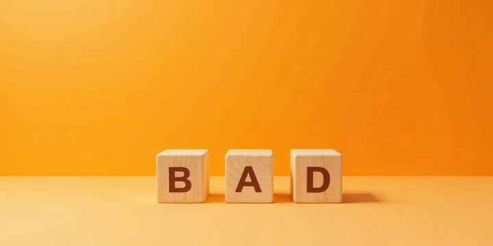 Wooden blocks spelling out the word bad against a vibrant orange backdrop