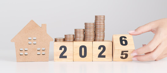 2025 end year to Happy New Year 2026 with house model and Coins stack. real estate, Home loan, tax, investment, mortgage, financial, savings and New Year Resolution concepts