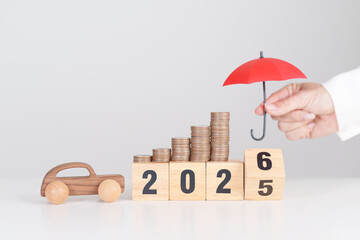 2025 end year to Happy New Year 2026 with red umbrella over money stack. car Insurance, Financial, vehicle Repair and Maintenance, Automobile Tax. Money Saving and New Year concept