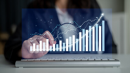 A business professional examines digital data charts displayed on a laptop screen, showcasing...