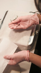 Professional manicure. Nail hygiene. Female master hands taking tools forceps preparing for steam sterilization instruments from bacterial viral infections.