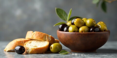 A rustic still life featuring a bowl of assorted olives and slices of crusty bread