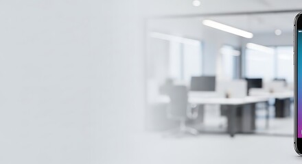 Fototapeta premium Smartphone displayed in front of a blurred office space with desks and chairs visible in the background