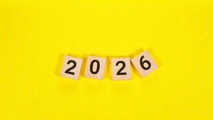 Wooden Tiles with "2026" Numbers Against a Bright Yellow Background, Symbolizing New Year Transition and Planning