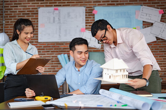 architect, engineer, engineering, architecture, design, plan, plans, construction, Team of architects and engineers collaborating on a building model and blueprints. - Powered by Adobe