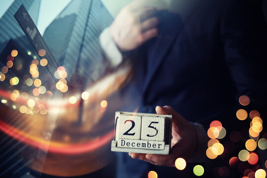 Businessman hand in a suit holding wooden cube with 25 december text . Resolution, strategy, solution, goal, business and New Year holiday concepts
