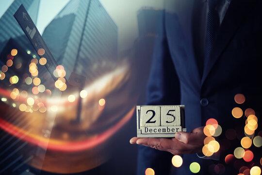Businessman hand in a suit holding wooden cube with 25 december text . Resolution, strategy, solution, goal, business and New Year holiday concepts