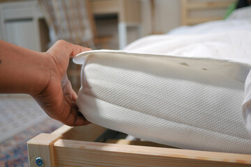 Adjusting a mattress in a cozy bedroom setup